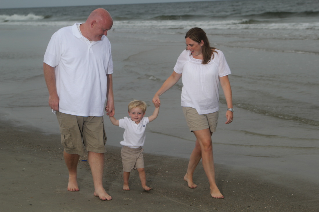 Man, woman, and boy walking on the beach